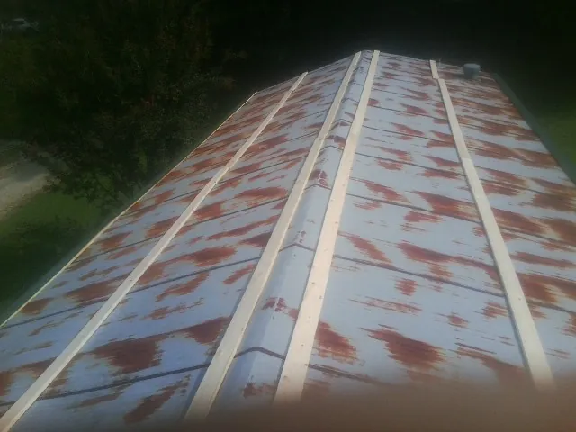 Rusted metal roof panels with new wood purlins before replacement — Storm Damage Roof Repair in Oxon Hill by Roofing Brothers