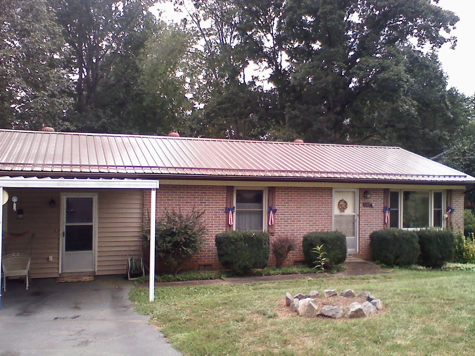 Bronze metal roof and carport on a brick ranch home — Roof Repair work by our crew in Oxon Hill