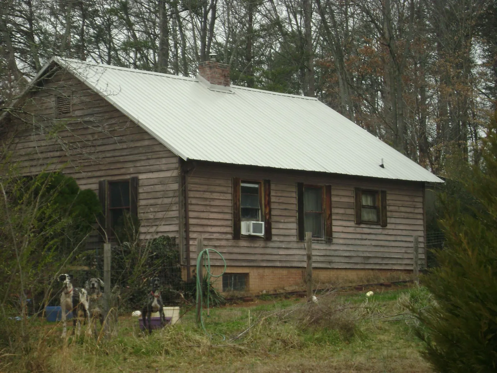 White metal roof on an old wood sided farmhouse, from a Asphalt Shingle Roof Repair job in Oxon Hill